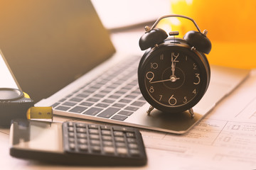 Time for working concept office worker is almost finish working, Alarm clock on laptop and plan...