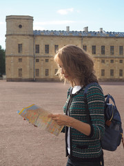 Woman tourist with map on the street. Travel guide, tourism in Europe. The ancient city of Gatchina.