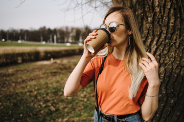 beautiful young girl drinks coffee outdoors