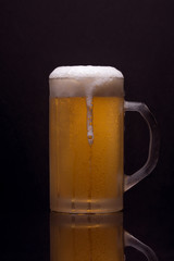 Cold beer with blond beer on dark background