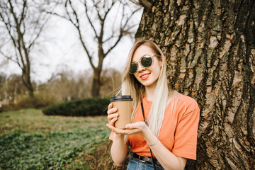 beautiful young girl drinks coffee outdoors
