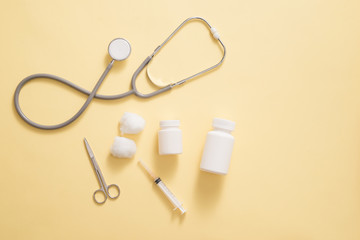 Health care concept. Composition with pills and medical stuff on yellow background