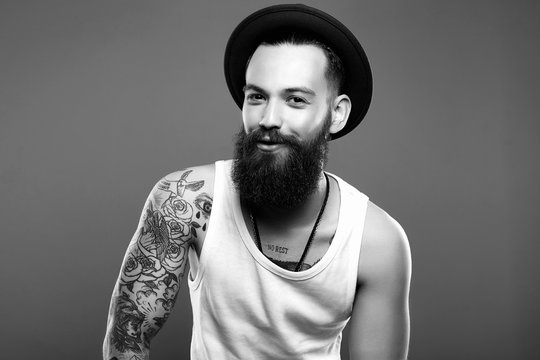 Man in Hat and Tattoo. Smiling Hipster boy