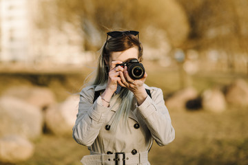 Portrait of a beautiful young blond woman with a camera, lifestyle