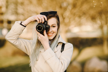 Portrait of a beautiful young blond woman with a camera, lifestyle