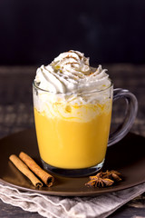 Tasty Pumpkin Latte with Spices Whipped cream on top on a Dark Wooden Background Autumn Hot Beverage
