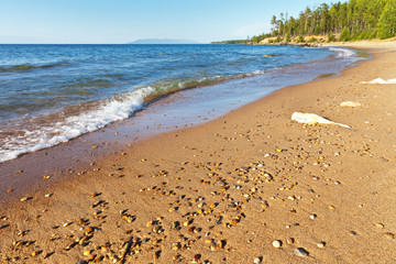 Warm summer afternoon at the shore of Lake Baikal. Beautiful sandy beach on the east coast