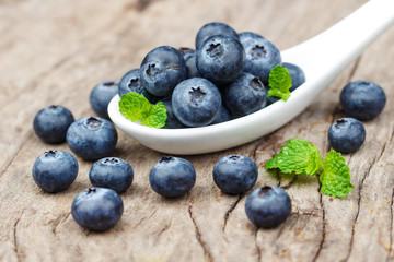 Blueberries in white spoon on wooden table, Healthy eating and nutrition concept