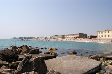 Fototapeta na wymiar Big stones near pier and view of the beach on the Romanian sea resort Eforie Nord.