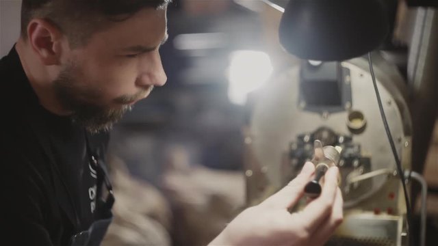 Man checking coffee beans in roaster