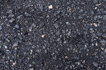Fototapeta premium Black and gray asphalt with rocks background texture closup