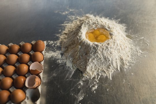 Close up of flour with egg yolks on countertop