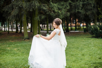 A beautiful bride in wedding dress dancing alone in field