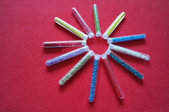 pattern of tubes with small beads sun red background