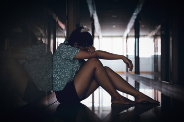 Obraz na płótnie Canvas lonely sad woman sitting and crying at corridor