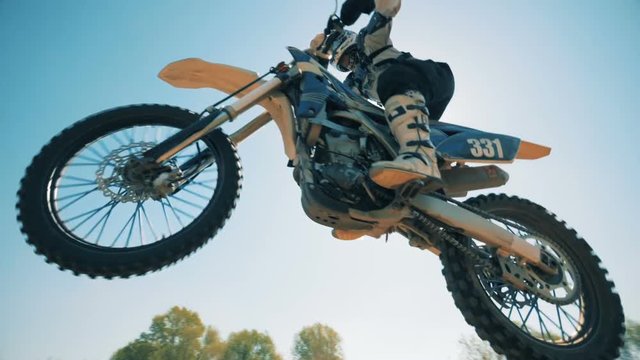 Deserted landscape with an FMX-rider performing a trick