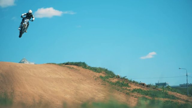 Slow motion footage of a motorcycler's leap above the hill. Slow motion