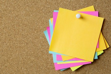 collection of colorful variety post it. paper note reminder sticky notes pin on cork bulletin...
