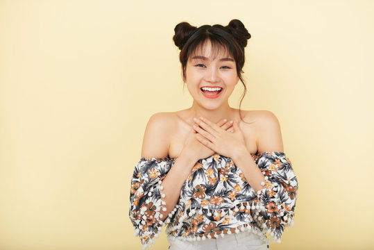 Portrait of happy Asian woman against beige background