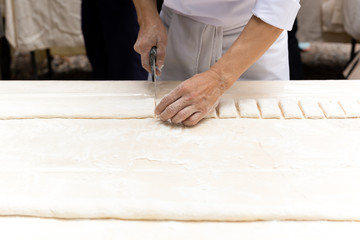 Chef cutting a pastry dough with pizza knife