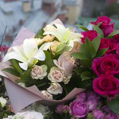 the White lilies and colorful roses in kraft paper as a birthday present