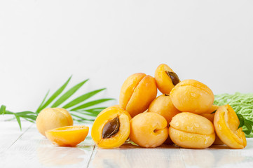 Ripe yellow apricots close-up on a light background.