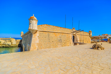 Fort of Ponta da Bandeira, a military architecture at entrance of the harbor in Lagos, Algarve, Portugal. The fortress is near Praia do Cais da Solaria. Blue sky with copy space © bennymarty