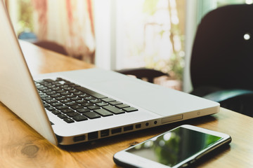 Business laptop computer with cell phone on table