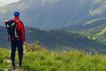 Fototapeta na wymiar Adventurer on the green mountain slope