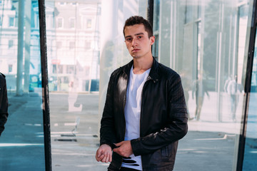 beautiful and attractive guy is standing in the city, posing.