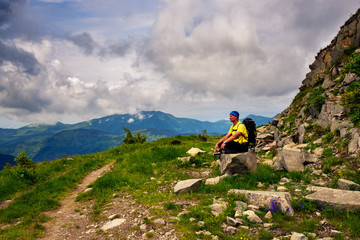 Fototapeta premium Adventurer is relaxing on the mountain trail