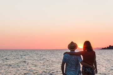 Fototapeta premium Young couple enjoying sunset by the sea