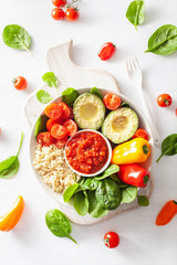vegan buddha bowl. healthy lunch bowl with avocado, tomato, bell peppers, quinoa and salsa