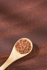 Organic quinoa red seeds - Chenopodium quinoa. Wooden spoon