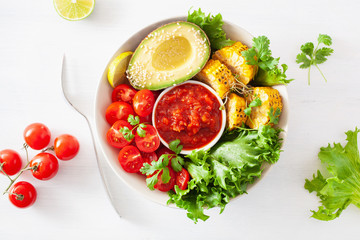 vegan buddha bowl. healthy lunch bowl with avocado, tomato, sweet corn and salsa