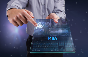 The concept of business, technology, the Internet and the network. A young entrepreneur working on a virtual screen of the future and sees the inscription: MBA