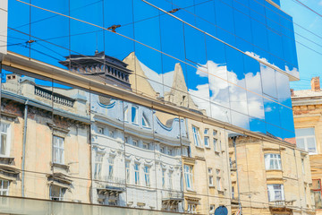 reflection in new glass building of old architecture