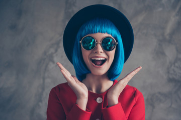 Wow! Portrait of glad excited girl in eyeglasses blue wig holding two palms near face with wide...