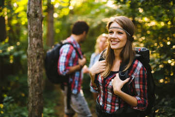 Fototapeta premium Beautiful woman and friends hiking in forest