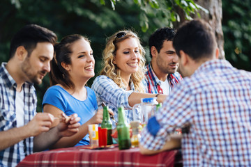 Group of happy people eating food outdoors