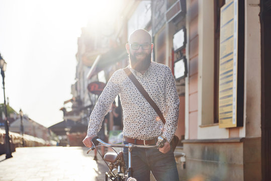 Portrait of bearded man with bicycle smiling at camera