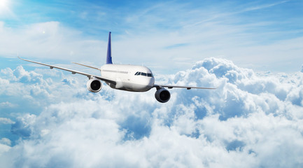 Fototapeta na wymiar Commercial airplane jetliner flying above clouds