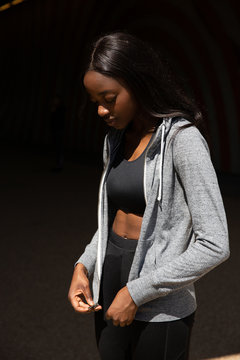 Young woman zipping hoodie