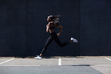 Young woman running on sports court