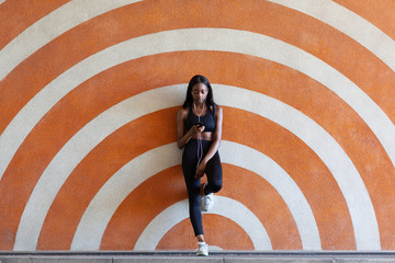 Young woman leaning against patterned background