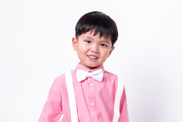 Smiling boy wears formal pink shirt and bow tie.