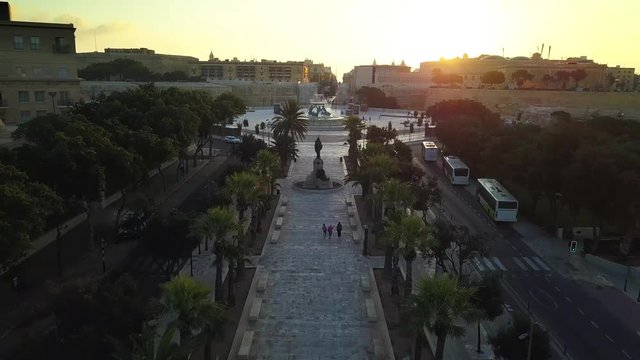 Valletta, Malta - 4K flying above Triq Sarria towards the refurbished Triton Fountain and Valletta city gate at sunrise