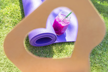 Like us shadow icon, dragon fruit purple milk shake and yoga mat on grass lawn like concept 