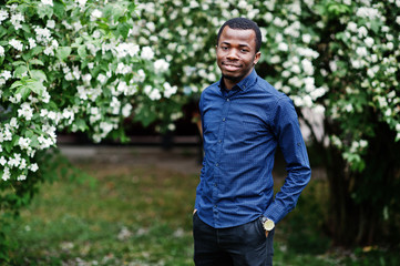 Naklejka na ściany i meble African man posed at street of city wear on blue shirt and black pants.