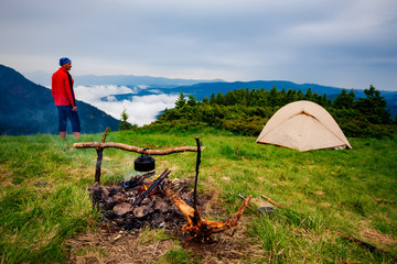 Fototapeta na wymiar Adventurer relaxes in the camp next to the bonfire